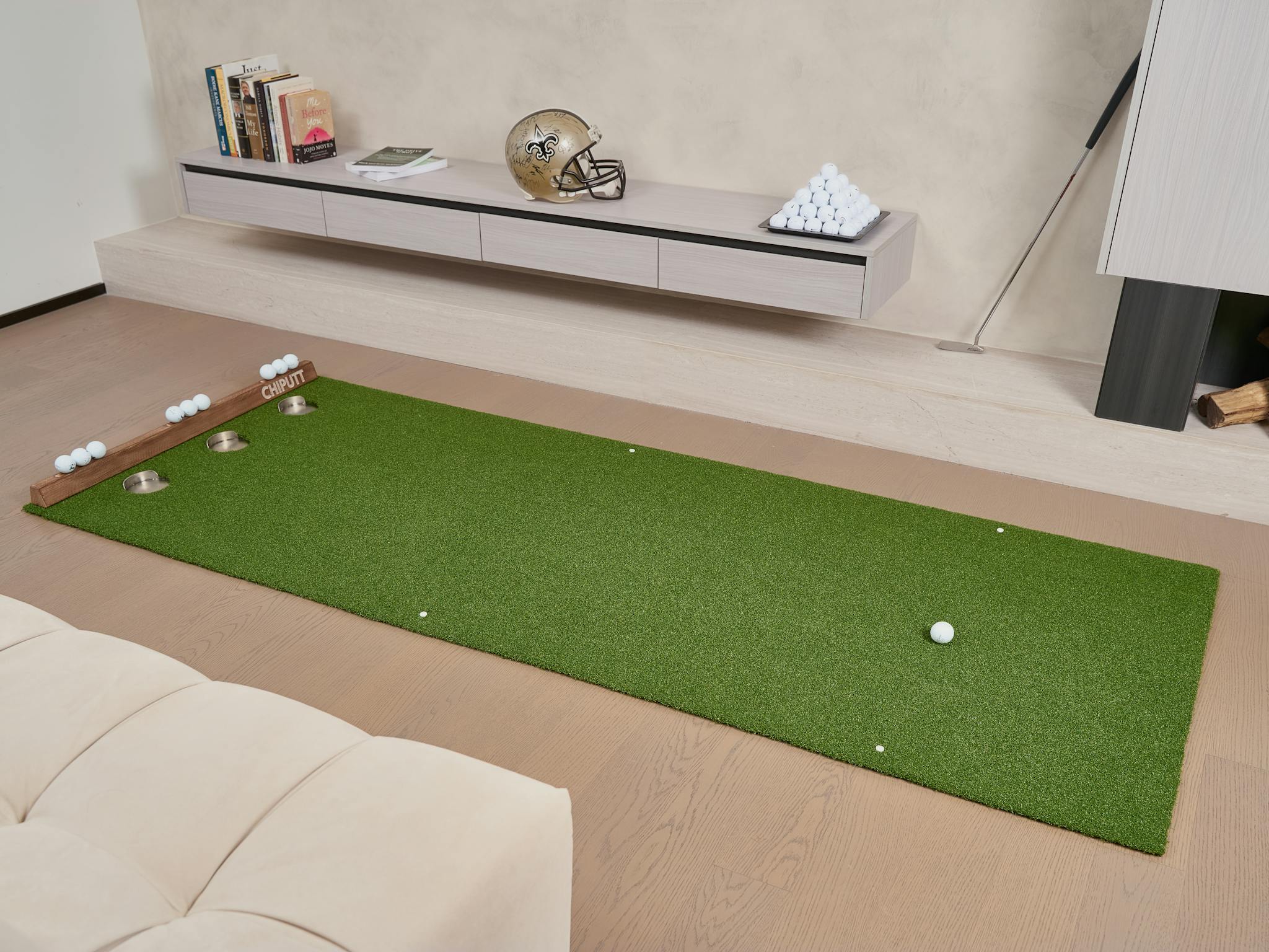 Indoor putting green with golf balls and equipment, perfect for practice at home.